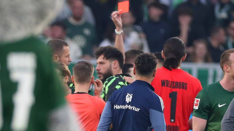 Am Ende der Rudelbildung zückt Schiedsrichter Florian Exner die Rote Karte für Wolfsburgs Ersatztorwart Marius Müller. 