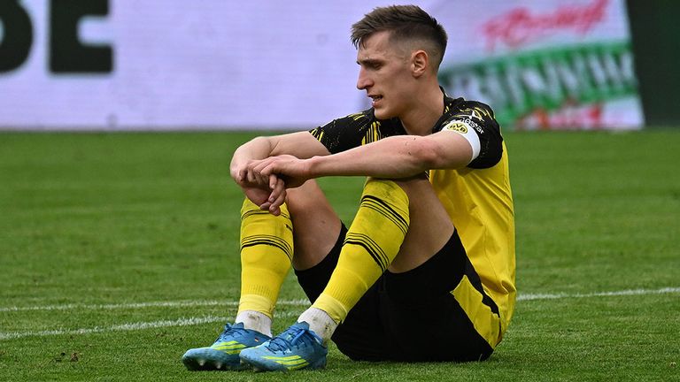 BVB-Star Nico Schlotterbeck sitzt enttäuscht auf dem Rasen.