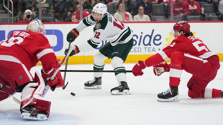 Detroit-Abwehrmann Moritz Seider (r.) kann den Schuss von Wild-Angreifer Matt Boldy (M) nicht mehr blocken.