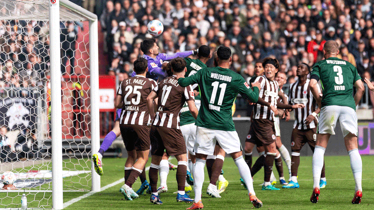 Torwart Nikola Vasilj (FC St. Pauli) wird attackiert und faustet den Ball ins eigene Tor zum 1:2 für den VfL Wolfsburg.
