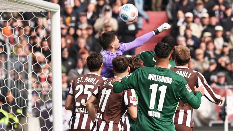 Torwart Nikola Vasilj (FC St. Pauli) wird attackiert und faustet den Ball ins eigene Tor zum 2:1 für den VfL Wolfsburg.