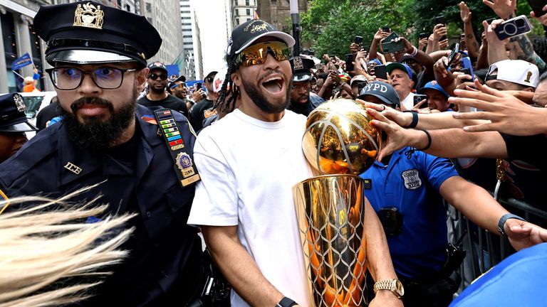 Knicks-Star Jalen Brunson präsentiert den zahlreichen Fans die NBA-Trophäe.