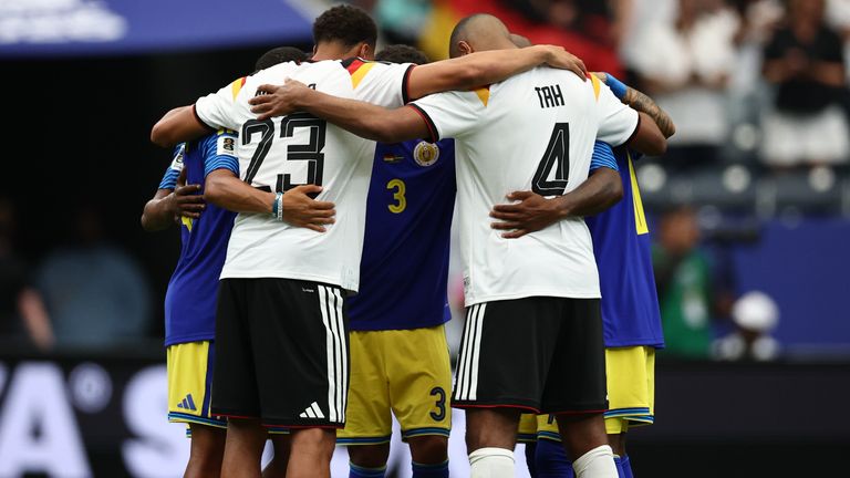 Felix Nmecha (l.) und Jonathan Tah (r.) im gebet mit drei Spielern Curacaos.