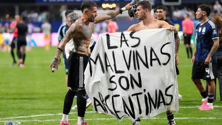 Argentinische Spieler nach dem Spiel gegen England mit einem Plakat, das an den Falklandkrieg im Jahr 1982 erinnert.