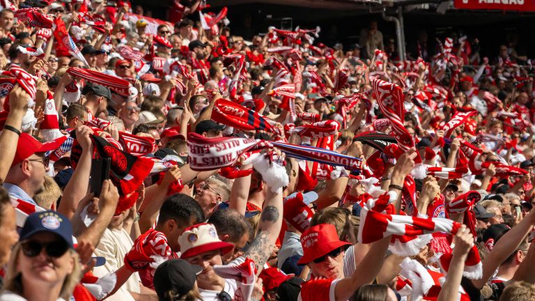 Die Fans des FC Bayern München schwenken ihre Schals.