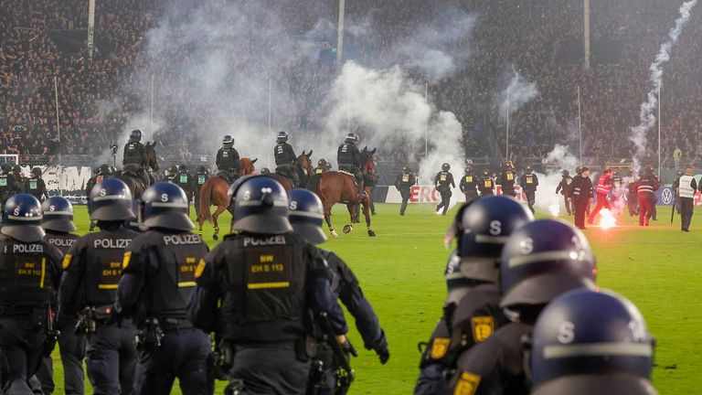 Polizeikräfte stürmen nach den Krawallen im Pokalspiel in Mannheim den Platz.