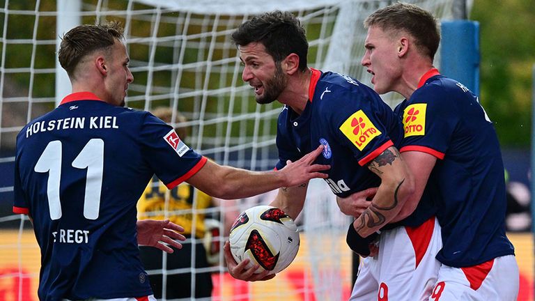 Torschütze Giorgi Kvilitaia (M) wird von seinen Teamkollegen von Holstein Kiel  gefeiert.